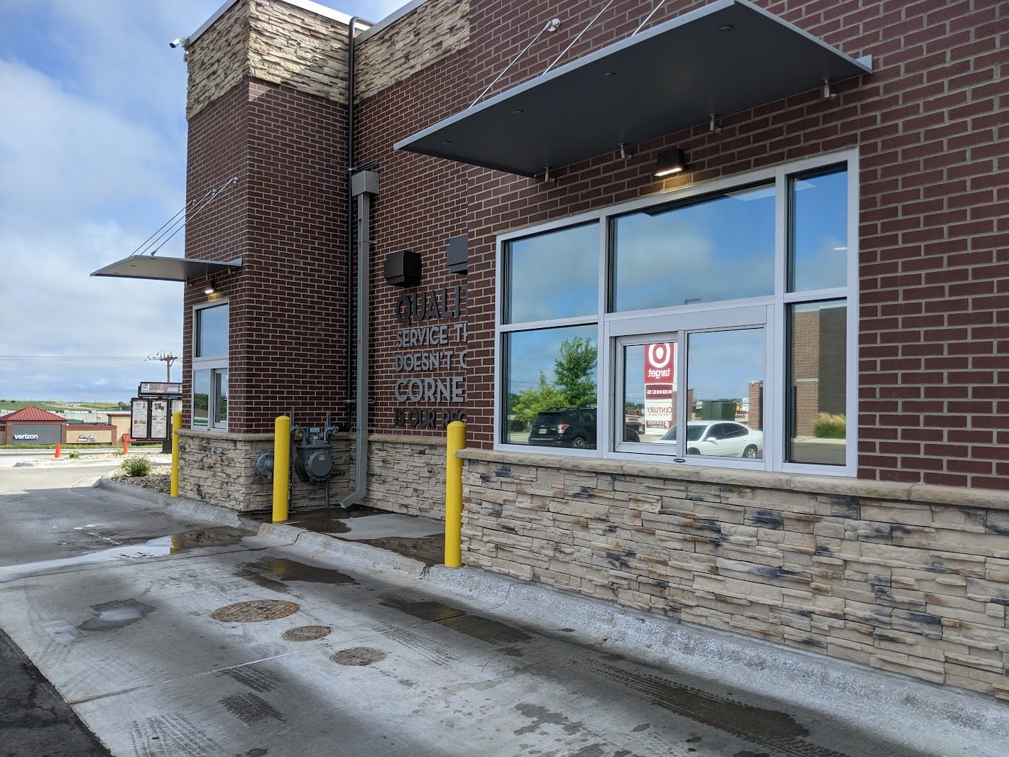 Brick commercial building with storefront windows and drive-up lane