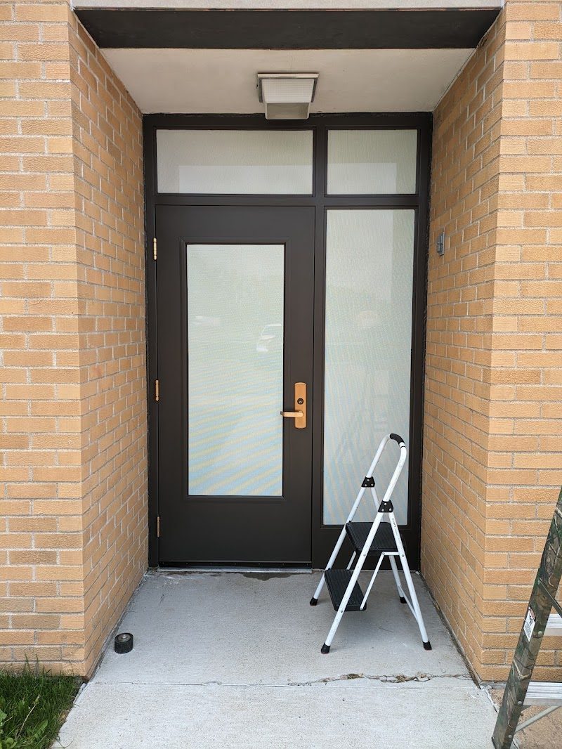 Frosted glass entry door with a ladder nearby