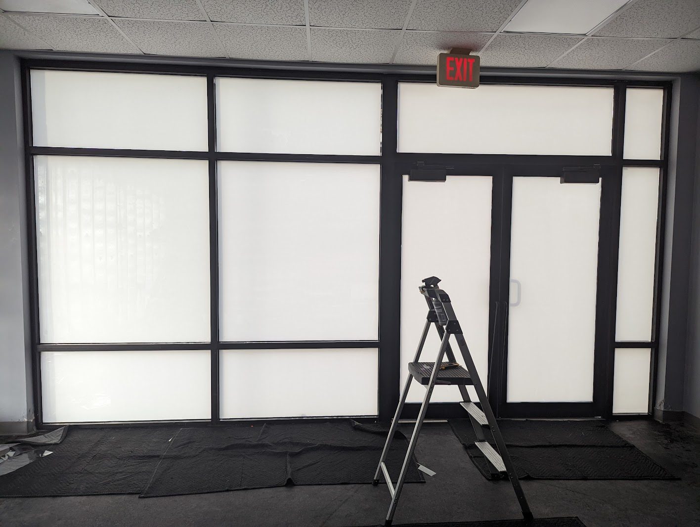Frosted film on a storefront door and windows with a ladder