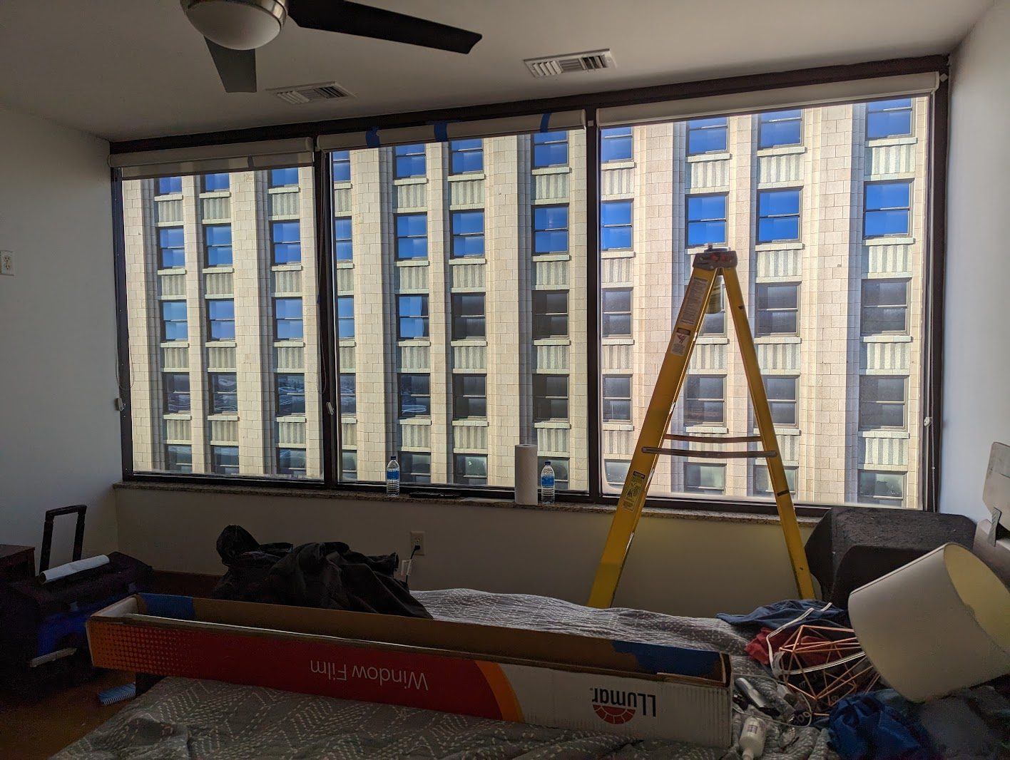 Ladder at a wall of office windows overlooking a city